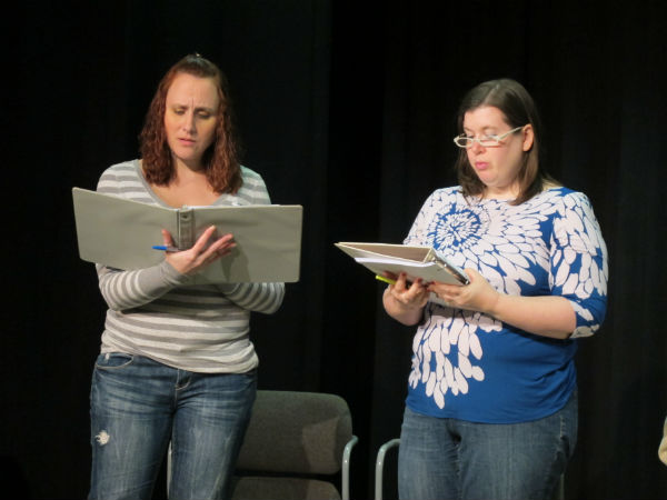 The prison guard (Stevie Holcomb, at right) breaks the news to inmate Linda (Heather Sexton) that her daughter has gone missing, and the sheriff is on the phone to talk to her.