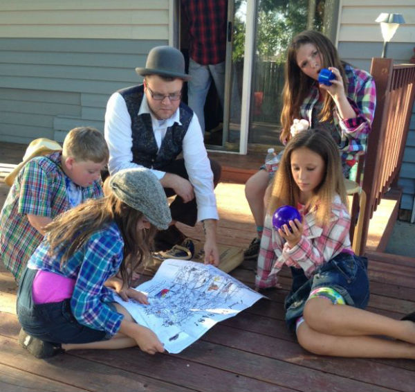 William Shields, Seja Foster, Micah Hornsby and Ryland Nelson go over a map of Kansas with the professor (Trevor Bionich). 